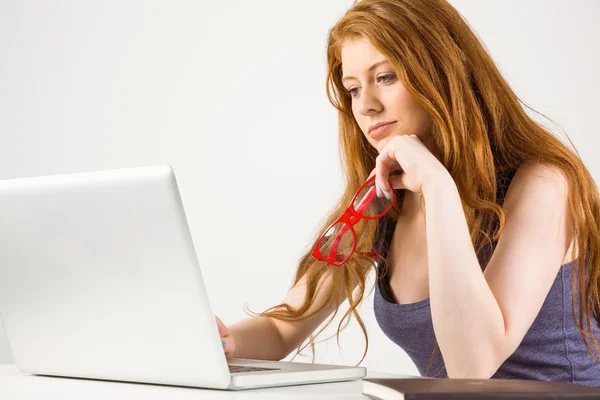 Jolie rousse travaillant sur un ordinateur portable — Photo