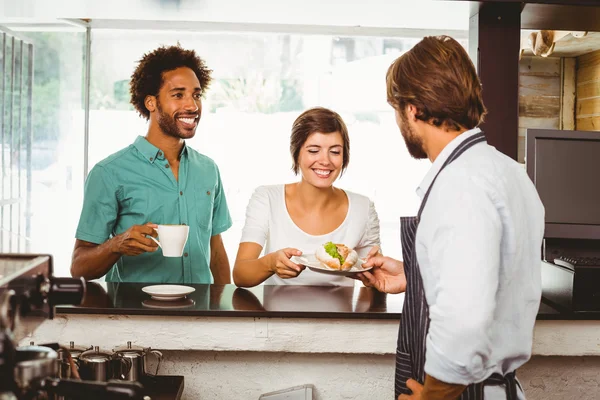 Barista som betjänar två nöjda kunder — Stockfoto