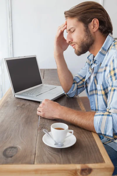 Casual man using laptop having coffee — Stock Photo, Image