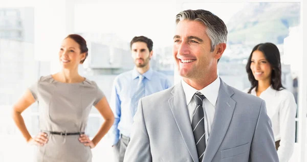 Un hombre de negocios sonriente y sus compañeros de trabajo — Foto de Stock