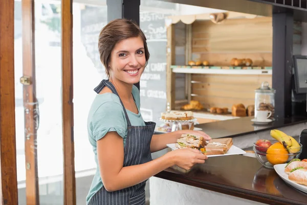 Hübsche Kellnerin hält Teller mit Essen — Stockfoto