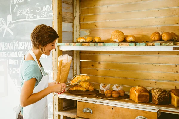 Hübsche Kellnerin nimmt Croissant — Stockfoto