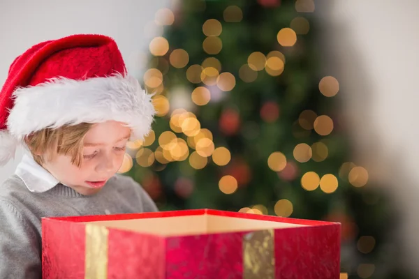 Kind öffnet sein Weihnachtsgeschenk lizenzfreie Stockbilder