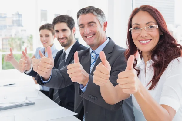 Business team all giving thumbs up Stock Photo
