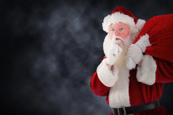 Композитное изображение Санта-Клауса, несущего мешок — стоковое фото