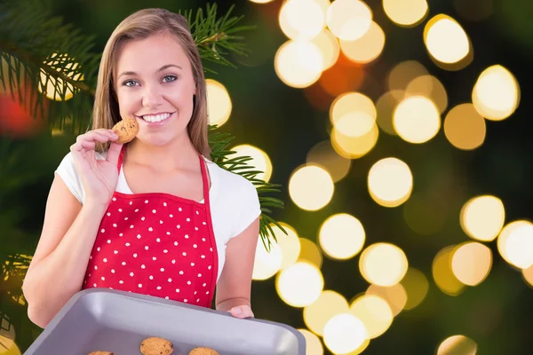 Pretty homemaker showing hot cookies — Stock Photo, Image