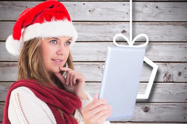 Composite image of festive blonde looking at tablet pc — Stock Photo, Image