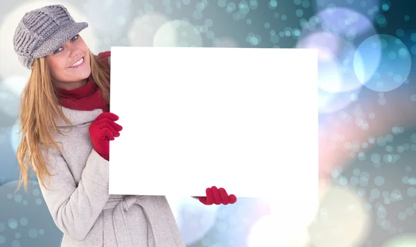 Glückliche Blondine in Winterkleidung zeigt Karte — Stockfoto