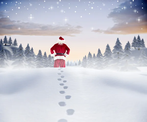 Composite image of santa walking in the snow — Stock Photo, Image