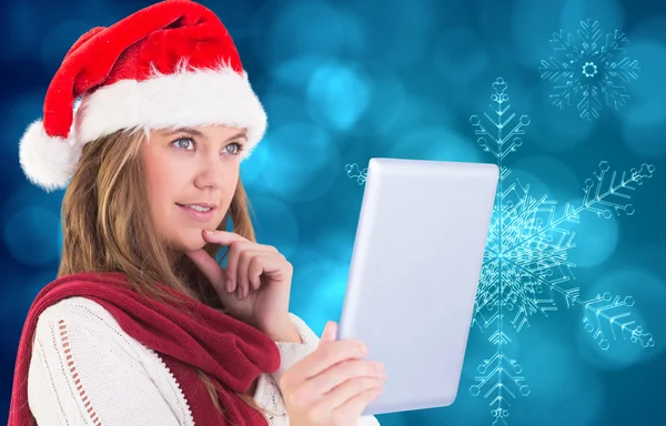 Composite image of festive blonde looking at tablet pc — Stock Photo, Image