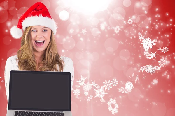 Samengestelde afbeelding van feestelijke blonde met een laptop — Stockfoto