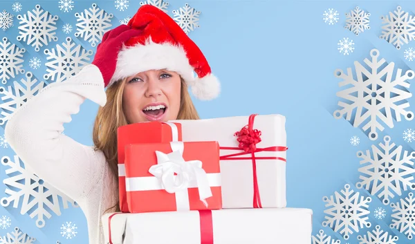 Imagen compuesta de rubia festiva sosteniendo un montón de regalos —  Fotos de Stock
