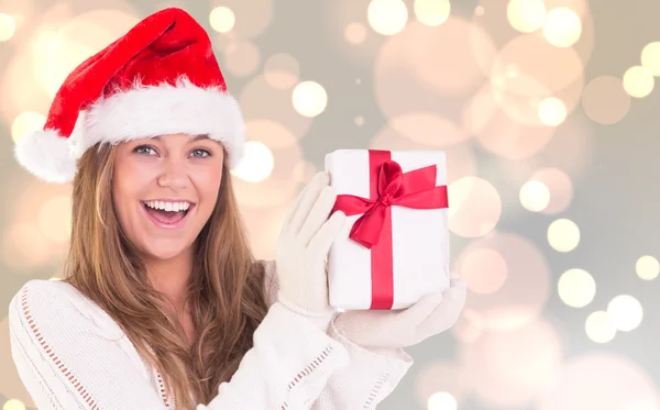 Zusammengesetztes Bild einer festlichen Blondine mit einem Geschenk — Stockfoto