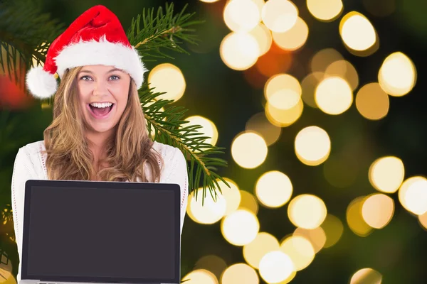 Composite image of festive blonde showing a laptop — Stock Photo, Image