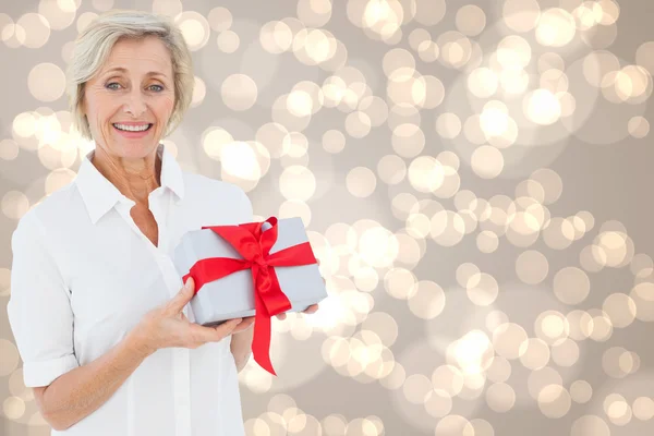 Samengestelde afbeelding van feestelijke vrouw met cadeau — Stockfoto