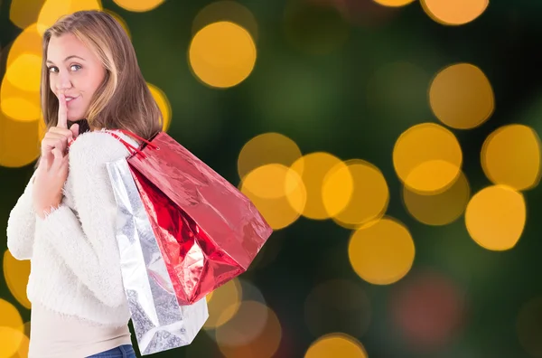 Pretty blonde keeping a secret holding bags — Stock Photo, Image