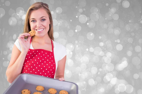 Pretty homemaker showing hot cookies — Stock Photo, Image