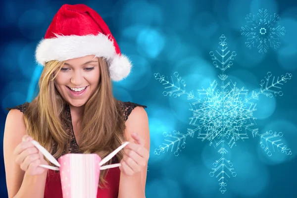 Composite image of festive blonde holding a gift bag — Stock Photo, Image