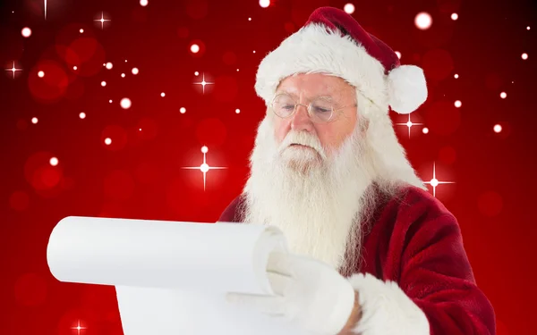 复合图像的圣诞老人检查他的名单 — 图库照片