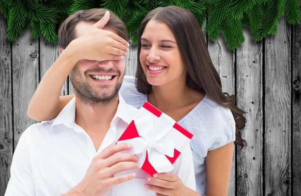 Woman surprising boyfriend with gift — Stock Photo, Image