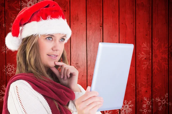 Composite image of festive blonde looking at tablet pc — Stock Photo, Image