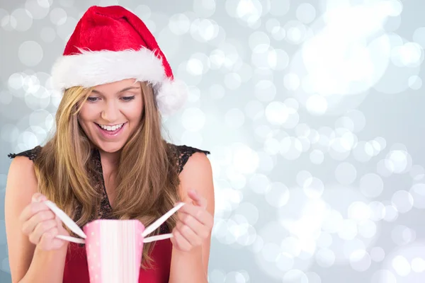 Loira festiva abrindo um saco de presente — Fotografia de Stock