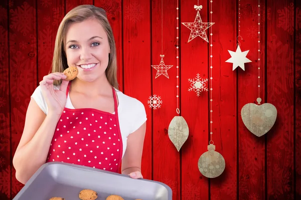 Pretty homemaker showing hot cookies — Stock Photo, Image