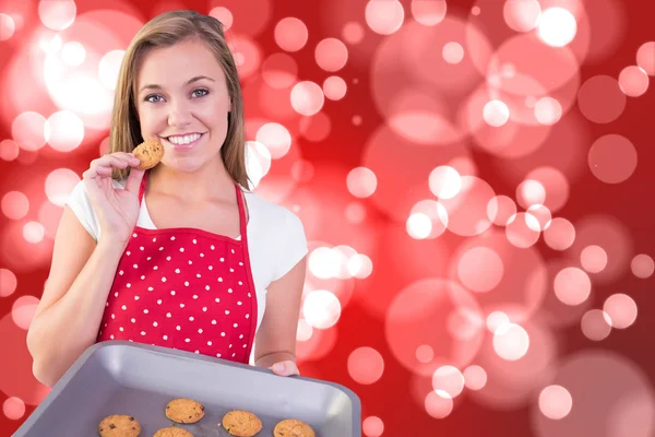 Pretty homemaker showing hot cookies — Stock Photo, Image