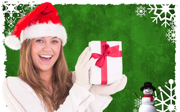 Composite image of festive blonde holding a gift Stock Photo