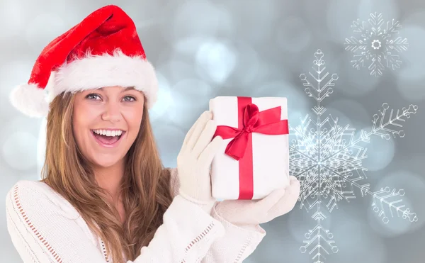 Composite image of festive blonde holding a gift Royalty Free Stock Photos