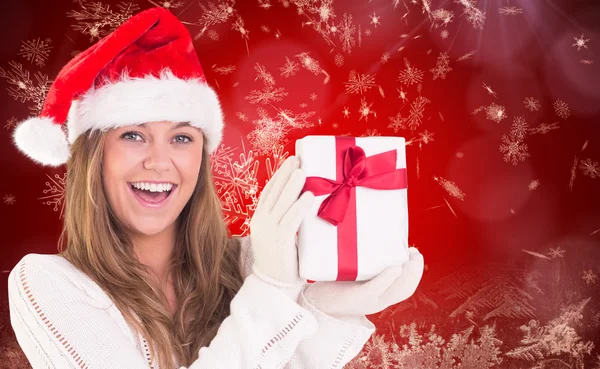 Composite image of festive blonde holding a gift Royalty Free Stock Photos