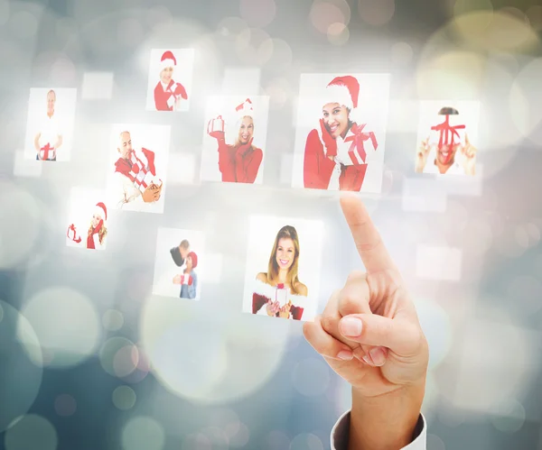 Composite image of hand pointing to christmas people collage — Stock Photo, Image