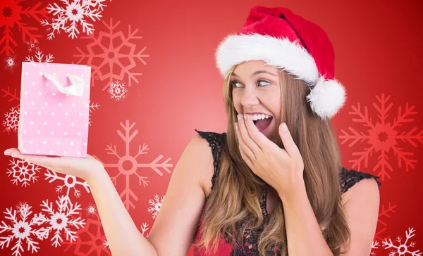 Zusammengesetztes Bild einer festlichen Blondine mit einer Geschenktüte — Stockfoto