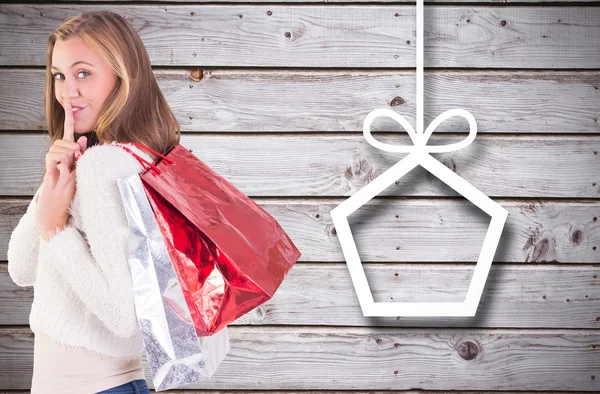 Pretty blonde keeping a secret holding bags — Stock Photo, Image