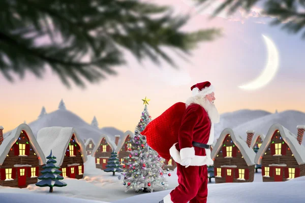 Zusammengesetztes Bild des Weihnachtsmannes mit Sack und Pack — Stockfoto