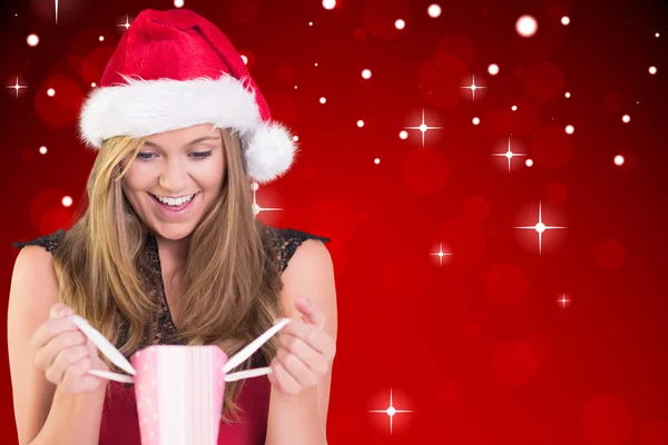 Festliche Blondine öffnet eine Geschenktüte — Stockfoto