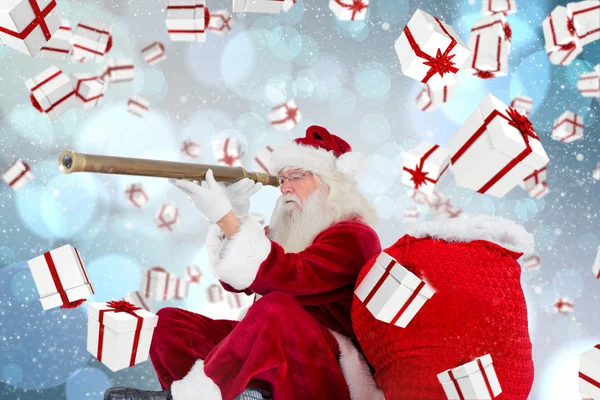 Složený obraz santa Claus při pohledu dalekohledem — Stock fotografie