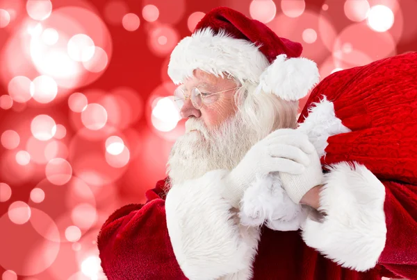 Composite image of santa claus carrying sack — Stock Photo, Image