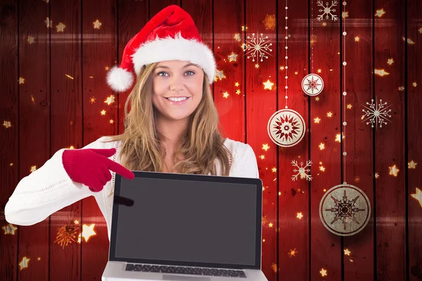 Samengestelde afbeelding van feestelijke blonde met een laptop — Stockfoto