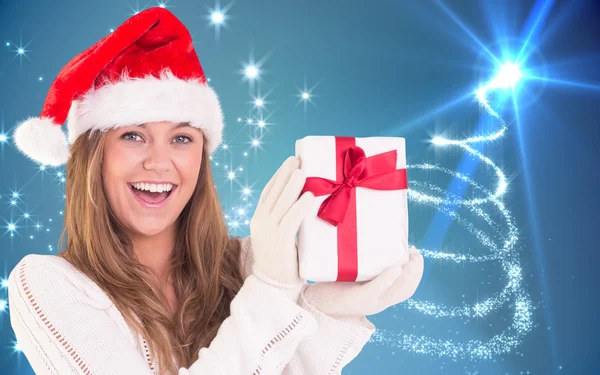 Imagen compuesta de rubia festiva sosteniendo un regalo — Foto de Stock