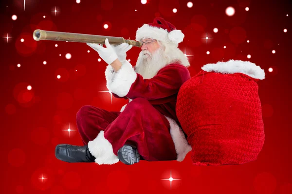 Композитное изображение Санта-Клауса, смотрящего в телескоп — стоковое фото