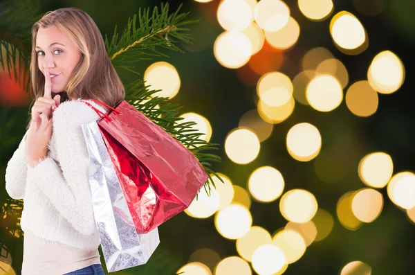 Pretty blonde keeping a secret holding bags — Stock Photo, Image