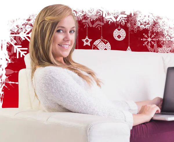 Pretty blonde relaxing on sofa with laptop — Stock Photo, Image