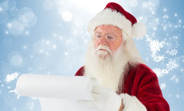 Composite image of santa claus checking his list — Stock Photo, Image