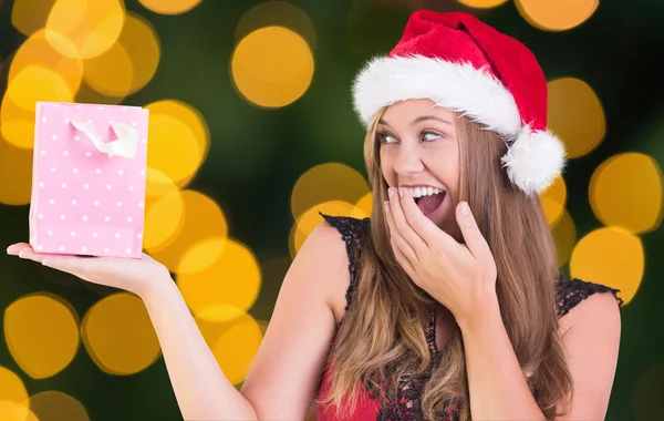 Composite image of festive blonde holding a gift bag — Stock Photo, Image