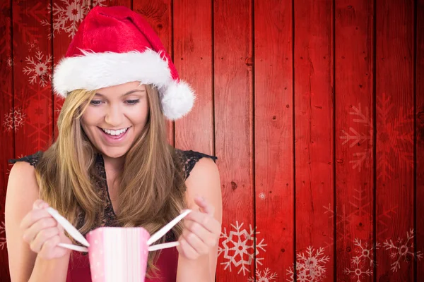 Composite image of festive blonde holding a gift bag — Stock Photo, Image