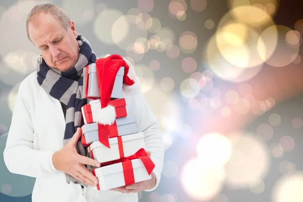 Imagem composta de homem festivo segurando presentes de Natal — Fotografia de Stock
