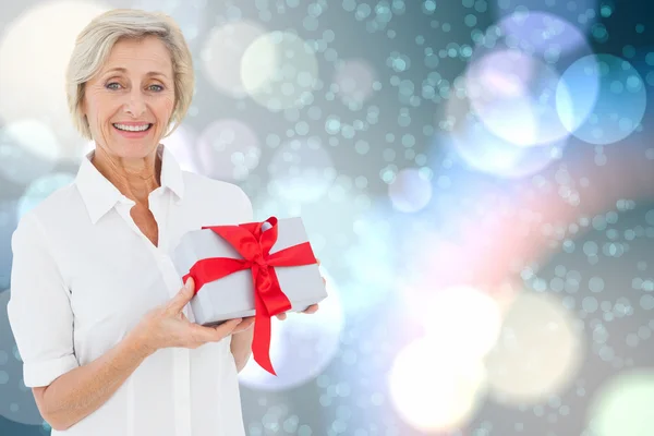 Složený obraz zralé ženy držící dárek — Stock fotografie