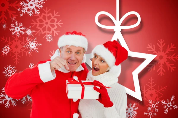 Festive mature couple holding gift — Stock Photo, Image