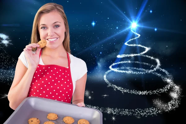 Pretty homemaker showing hot cookies — Stock Photo, Image